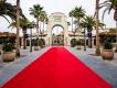 A red carpet leading up to an archway which reads Universal Studios Hollywood