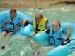 Dreamflight at Typhoon Lagoon Two children and one adult wearing life jackets and waving at the camera while sitting in water