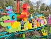 LEGO DUPLO Dino Adults and young children riding a rollercoaster designed to look like a dinosaur made with colourful DUPLO bricks