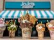 JoJo's ShakeBar in Orlando 5 large milkshakes topped with cream, marshmallows, candy floss and sprinkles, in front of sign reading JoJo's ShakeBar