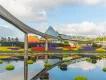 EPCOT at Walt Disney World Resort A monorail on a track above a lake with multi-coloured flowers along the bank and floating in the water