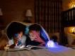 Disney Resort Hotels at Walt Disney World Resort Two young boys laying in bed reading a book with a torch