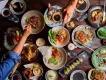 Visit Orlando's Magical Dining A table full of plates of food with people reaching over to take food with chopsticks