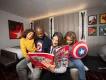 Hotel New York - The Art of Marvel A family of 4 sat on a bed reading a Marvel comic