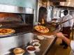 Dining at California Grill A chef taking a pizza out of a wood fired pizza oven at California Grill
