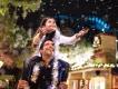 Christmas in Orlando A girl sitting on a man's shoulders holding her hands out to catch fake snow as it falls