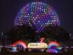 EPCOT Festival of the Arts Spaceship Earth lit up in rainbow colours behind a sign reading Festival of the Arts
