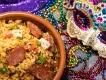 Mardi Gras in Orlando A dish of jambalaya on a table next to a sequined mask and multicoloured beads