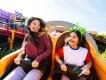 Two guests on Slinky Dog Dash in Disney's Hollywood Studios A woman smiling at a young girl on the Slinky Dog Dash ride, the girl has a headband on with a green alien head, three eyes and an antenna.
