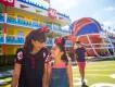 Disney's All-Star Sports Resort A woman and girl walking in front of a hotel designed to look like an American football pitch