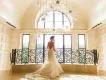 Orlando Weddings A woman in a wedding dress standing in front of a large window at the top of a grand staircase