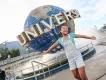 Universal Orlando Resort A girl standing with her arms outstretched in front of the Universal Studios globe