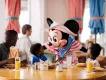 Dining at Walt Disney World Resort Minnie Mouse greeting two young children and their dad while they are sat round a table eating breakfast