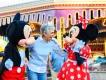 Orlando for Seniors An older woman smiling with Mickey and Minnie