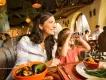 Dining at Walt Disney World Resort A mum and young girl sat at a table eating dinner. The girl is using binoculars to look out the window
