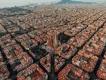 Barcelona Layout of Barcelona with a view of the Sagrada Familia cathedral. The city is laid out with straight roads and buildings shaped in squares. They all have the same colour scheme with white and orange walls and roofs.