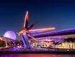 EPCOT EPCOT, the guardians of a galaxy triangular space ship coloured yellow and grey. In the background there is a white golf ball shaped building and the monorail.
