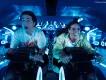 TRON Lightcycle/Run at Magic Kingdom Park Two young adults sat on motorcycles shaped vehicles TRON Lightcycle. They are leaning forward gasping with shock.
