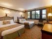 Disney Sequoia Lodge at Disneyland Paris A forest/Bambi themed hotel room with two beds, a chair and a dresser