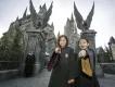 The Wizarding World of Harry Potter Two young girls wearing wizard robes and pointing magic wands at the camera while standing in front of Hogwarts Castle