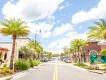 Sunset Walk in Orlando A road lined with palm trees in front of shops and restaurants