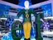 Elf Sculpture Sign of green letters saying elf in font from movie but instead of an L there is an ice sculpture of Buddy the Elf stood up straight wearing a dark green elf suit.