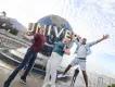 Universal Orlando Resort Three people jumping excitedly in front of the Universal Globe
