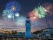 SeaWorld Orlando The iconic blue lighthouse at the front of the park with fireworks of many different colours exploding in the background above the silhouette of a ride,