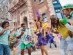 Mardi Gras at Universal Orlando Resort People dancing with Mardi Gras performers dressed in bright coloured, feathered costumes