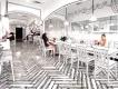 Twenty Pho Hour Black and white cartoon furniture inside of a restaurant, with people sat at tables with sauces on.