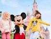 Kinder in Disneyland Paris  Zwei junge Mädchen springen mit Micky vor dem Schloss von Disneyland Paris