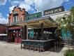 Raglan Road at Disney Springs An irish pub with a sign saying Raglan Road Irish Pub, there is a bar and multiple bar stools.