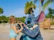 An adorable character meet-and-greet at a sunny Walt Disney World location, showing a young child playing with Stitch on the beach, a great example of fun outside the main theme parks for young families.