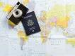 A US passport and camera resting on a world map, representing international travel, planning, and the major trends defining US travel in 2026.