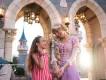 A young girl meeting Rapunzel in front of the castle at Disney World