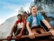Two young men laughing as they ride the Expedition Everest roller coaster train through snow-covered mountain peaks