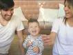A young family celebrating together at home with sparklers, smiling and laughing