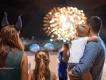 A family wearing Disney ears looking out at a nighttime fireworks display