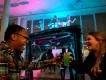 Two guests laughing and clinking colorful themed cocktails at a Universal Orlando Resort hotel Halloween Horror Nights bar experience