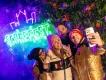Four friends taking a selfie in front of a glowing neon Scarefest sign