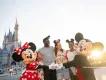 A family posing for a picture with Mickey Mouse and Minnie Mouse in front of Cinderella Castle