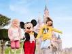 Children jumping with Mickey Mouse in front of a castle at Disneyland Paris