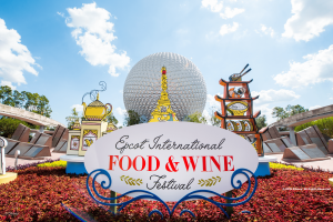 A sign reading "EPCOT International Food and Wine Festival" in front of Spaceship Earth