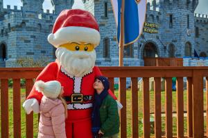 A boy and a girl looking up at LEGO Santa