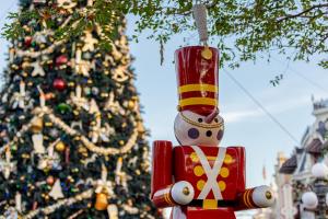 A toy solder in front of a giant Christmas tree 