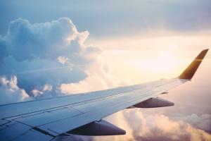 A view out of a plane window of a plane wing in the clouds