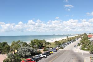 A view down a road running along a white sandy beach and blue ocean
