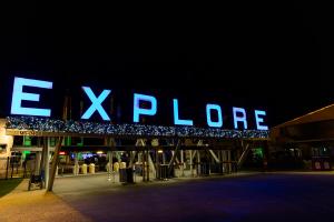An entrance gate decorated with Christmas decorations and "EXPLORE" lit up with blue lights