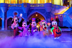 Mickey, Minnie, Goofy, Pluto and Donald Duck posing in Halloween costumes