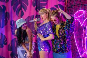 Two women posing with a Taylor Swift waxwork at Madame Tussauds London